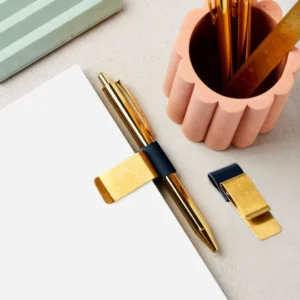 martha brook brass clip pen holder attached to a plain notebook
