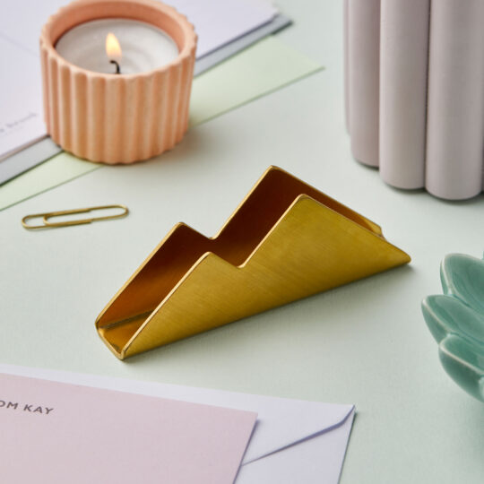 martha brook gold notecard holder on desk next to a tealight in a pink holder