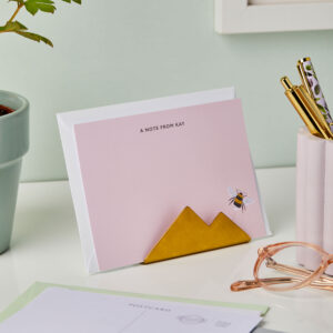 martha brook personalised stationery gold notecard holder displaying a pink notecard with a bumblebee in the bottom right corner