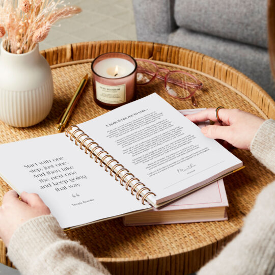 martha brook personalised ivf journal on side table with a candle showing a page on a note from the founder