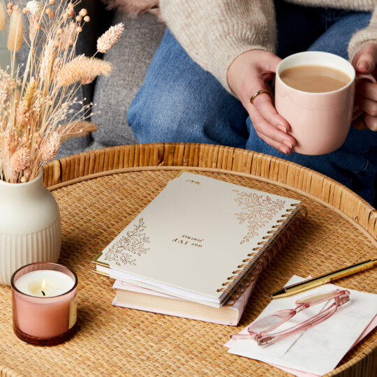 martha brook personalised ivf journal on side table with a candle with a cup of tea